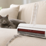 ChomChom Roller reusable pet hair remover removing cat fur from a fabric sofa.